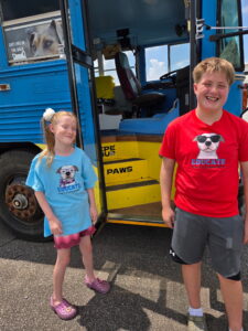 Picture of a boy and girl showing off T-shiirts with the text Educate Don't Discriminate for youth clothing.