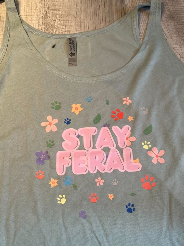 festival tank top with pink bubble lettering 'Stay Feral' and whimsical paw and flower patterns.